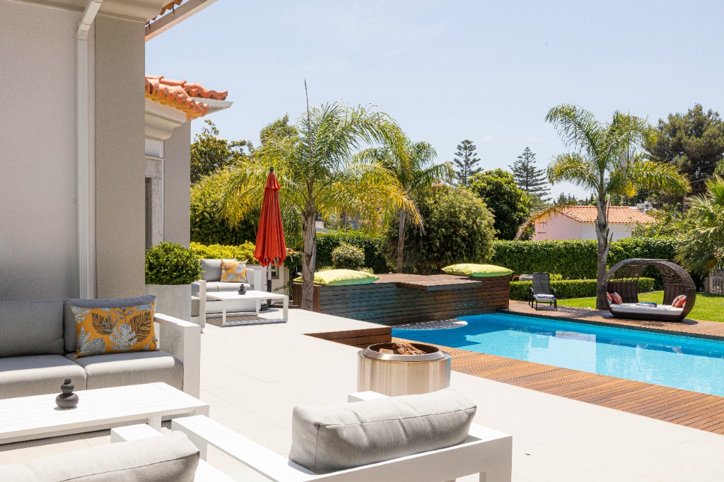 Resort-style backyard with pool, deck, and lounge areas